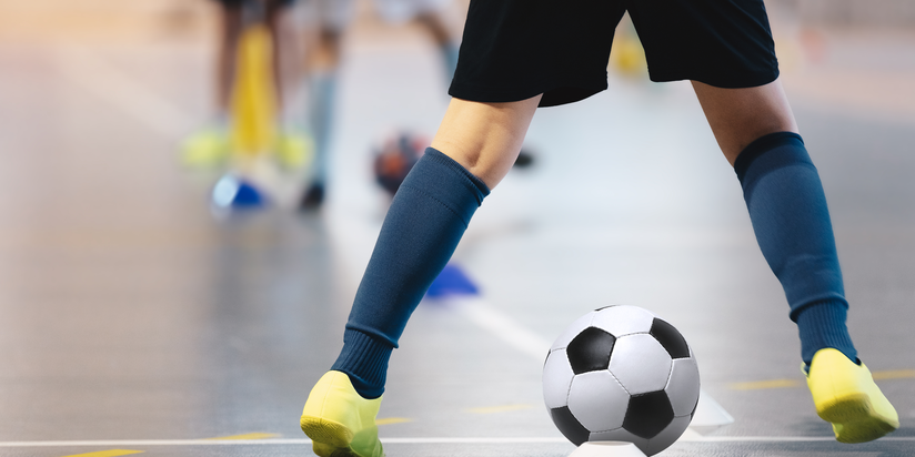 photo of an indoor soccer player with a soccer ball at its feet