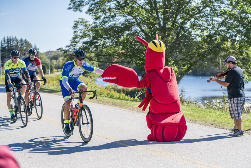 Lobster mascot giving a cyclist a high-five